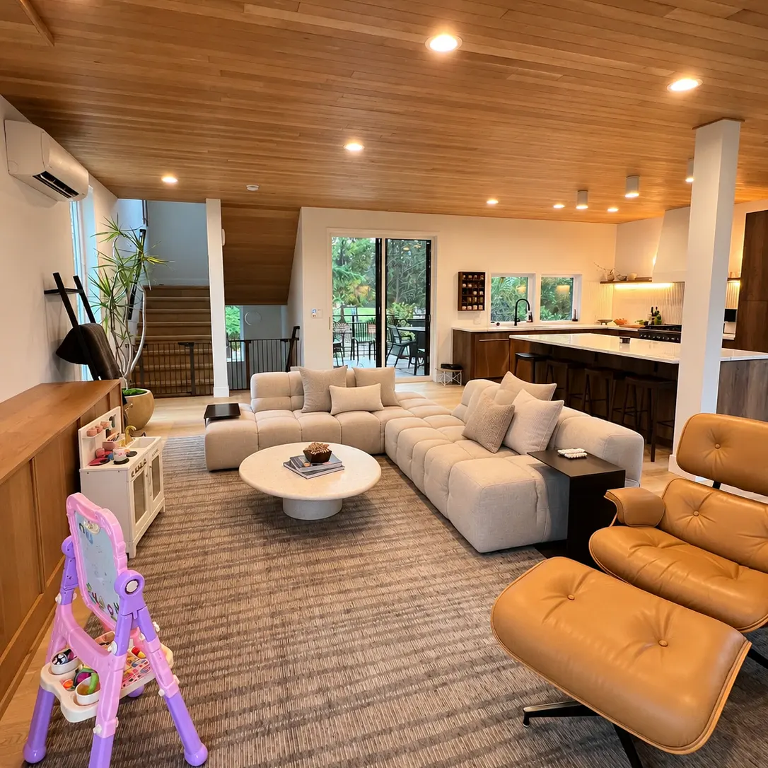 Bright living room with a wood ceiling, a light sofa and a child's easel, after a BBK Cleaners visit